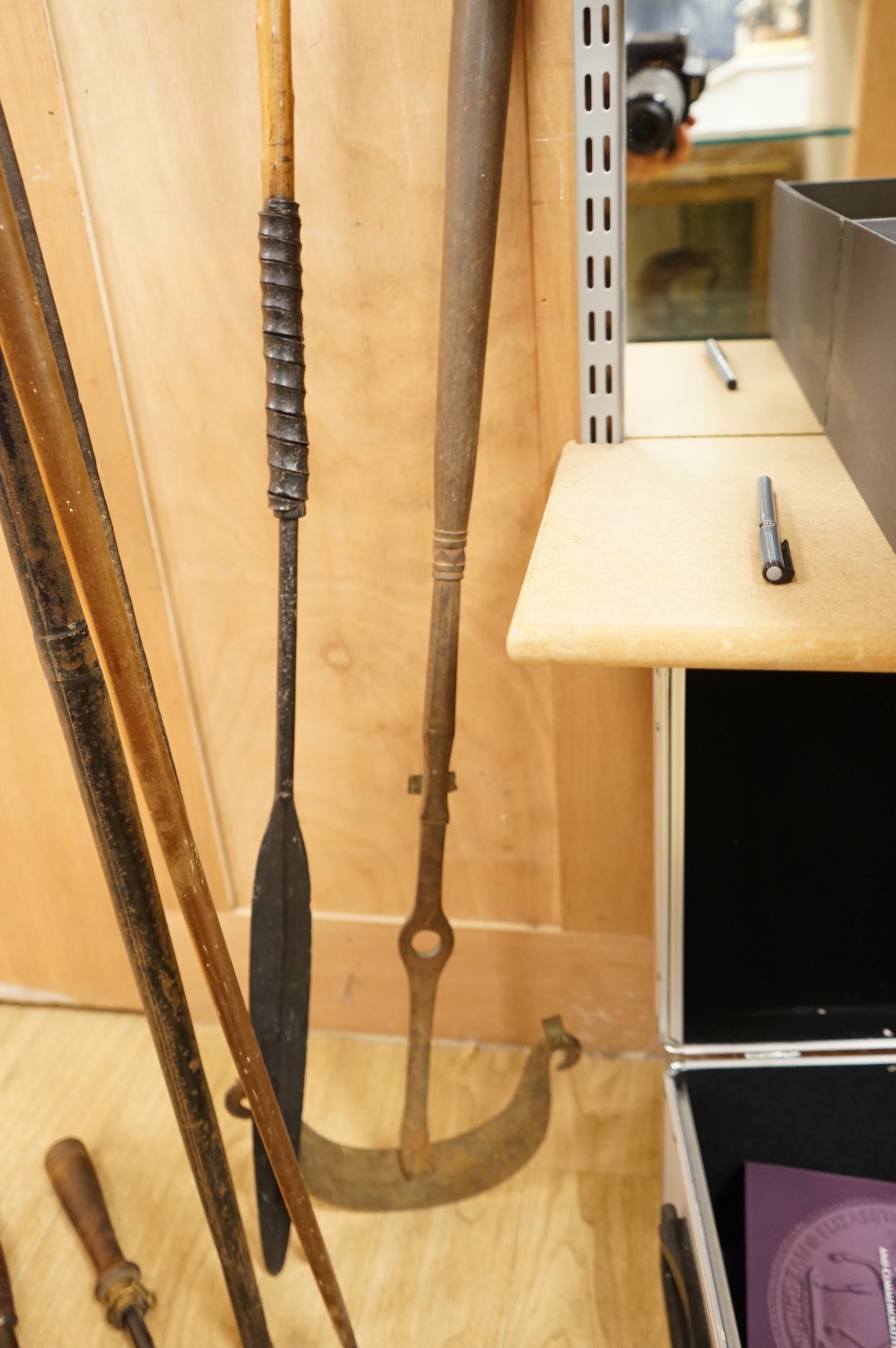 A collection of tribal spears, a fish hook, a cased snooker cue, etc.